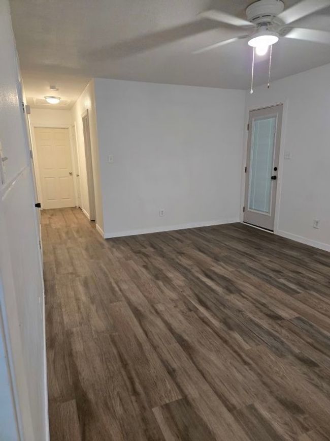 Empty room with dark wood-type flooring and ceiling fan | Image 10