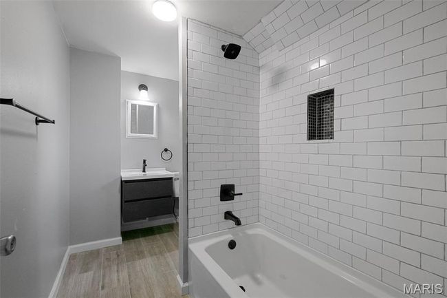 Bathroom featuring vanity, bathing tub / shower combination, and wood finished floors | Image 11