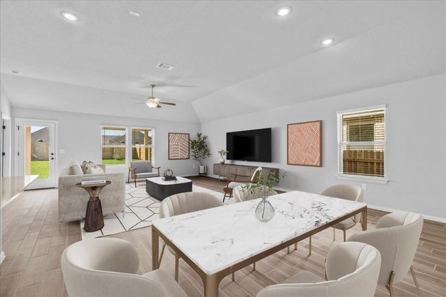 Dining space with vaulted ceiling, light wood-style floors, ceiling fan, visible vents, and recessed lighting | Image 12