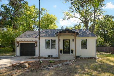 View of front facade featuring a front yard and a garage | Image 1