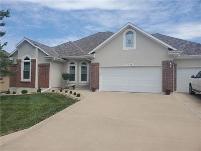 Single story home with a garage and a front lawn | Image 1