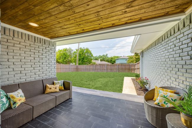 Fenced backyard with a patio area | Image 31