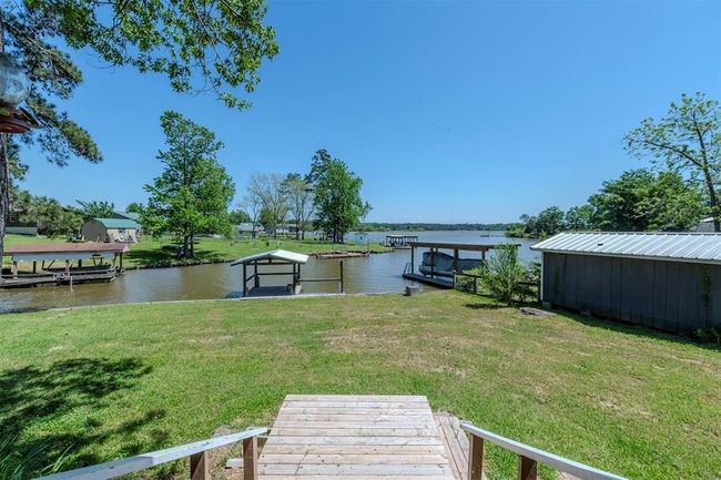 Enjoy an expansive covered back deck that spans the width of the home and overlooks the lake. | Image 4