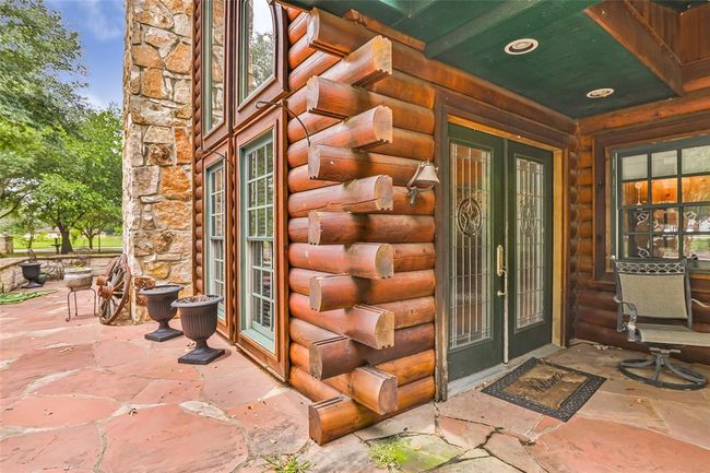 Experience serene living in this charming two-story log cabin, featuring a balcony, spacious patio, inviting pool, and gazebo—all set in a lush green paradise. Perfect for relaxation and entertaining. | Image 11