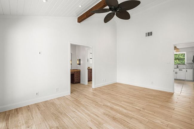 Unfurnished room with a ceiling fan, light wood-style floors, crown molding, a wood ceiling with exposed beams, and high vaulted ceiling | Image 17