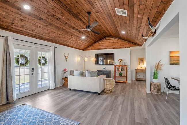 The living area brings warmth and character with vaulted wood ceilings, abundant natural light, and seamless flow to the outdoors. | Image 8