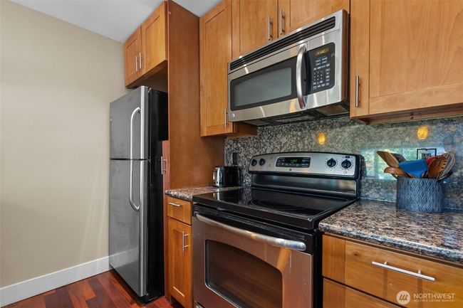 The Kitchen is where the magic happens! Gorgeous stainless steel appliances and plenty of shaker cabinetry for storing the kitchen tools and gorgeous slab granite. | Image 14