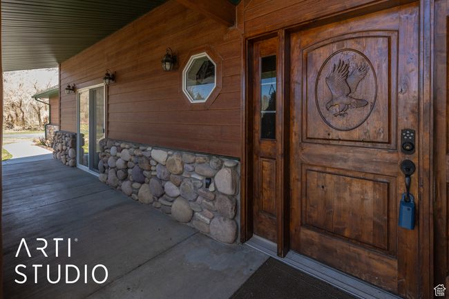 View of exterior entry with stone siding and covered porch | Image 9