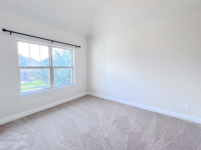 Carpeted spare room featuring baseboards and vaulted ceiling | Image 27