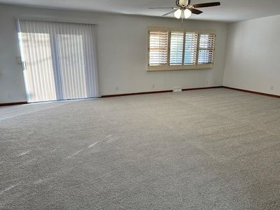 Empty room with carpet floors and ceiling fan | Image 2