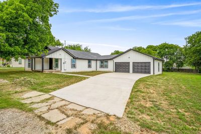 Ranch-style house featuring a front lawn and a garage | Image 1