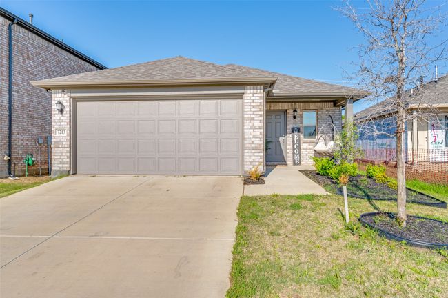 View of front of home with brick siding, roof with shingles, driveway, and an attached garage | Image 25