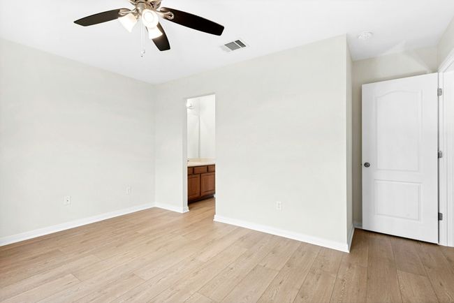 Empty room featuring ceiling fan, light wood-style flooring, and a smoke detector | Image 19
