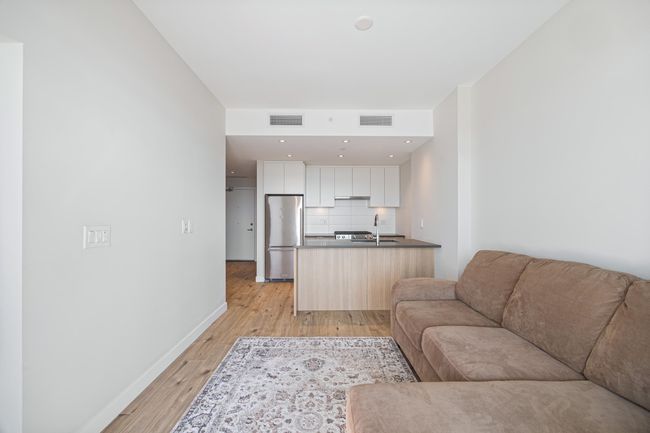 Living area with visible vents, light wood-type flooring, and baseboards | Image 10