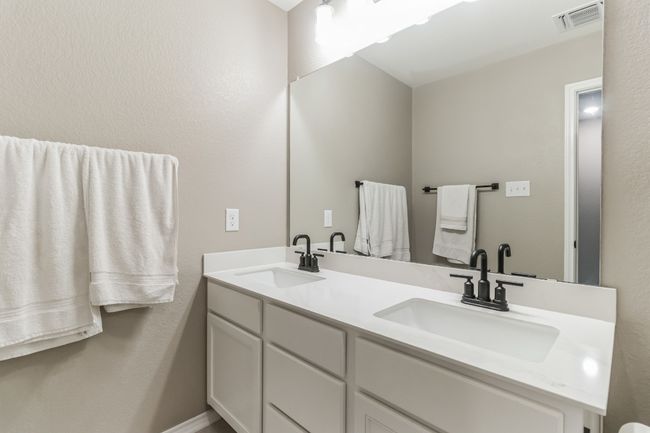 Bathroom featuring double vanity and a textured wall | Image 25