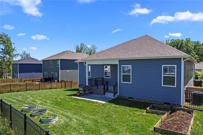 Rear view of property with a vegetable garden, central AC unit, and a shingled roof | Image 48
