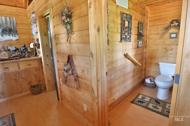 Half bathroom with wood walls and wood finished floors | Image 12