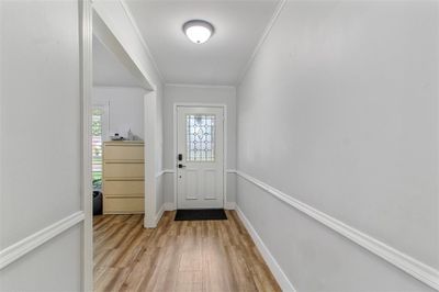 Welcoming Foyer: Bright and inviting space with elegant hardwood floors and a chic entry door that sets the tone for the rest of this charming home. | Image 3