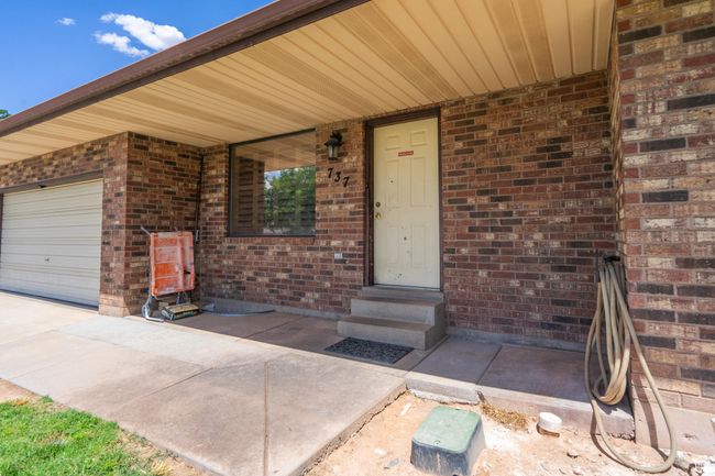 Doorway to property featuring brick siding and a garage | Image 14