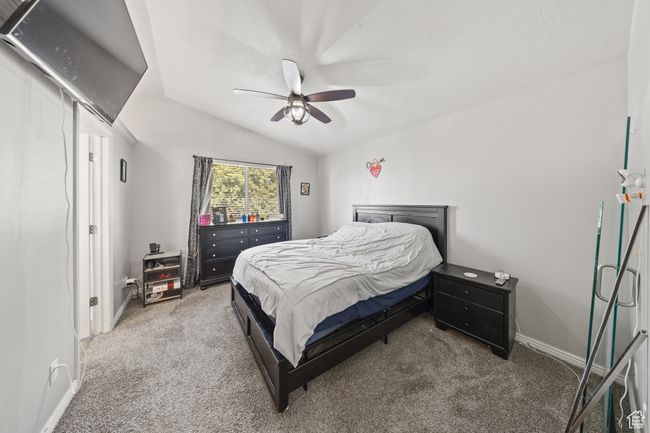 Bedroom featuring carpet, vaulted ceiling, and a ceiling fan | Image 15