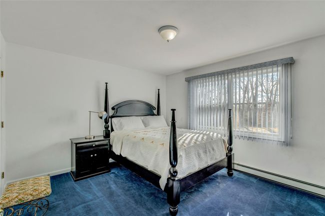 Carpeted bedroom with a baseboard heating unit | Image 16
