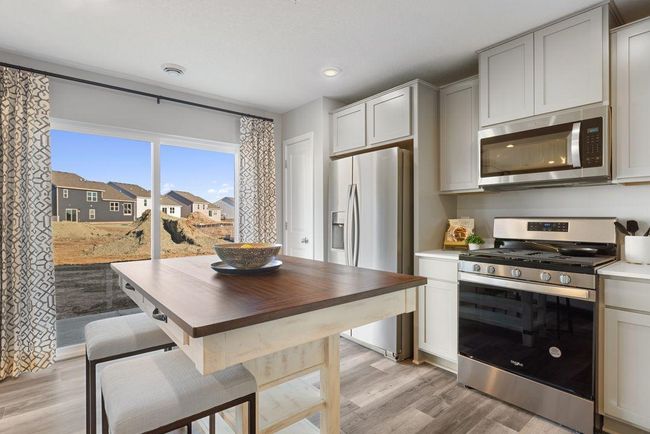 Dining area and kitchen with easy access to private rear patio. Photo is of model home. Colors and options may vary. Ask Sales Agent for details. | Image 5
