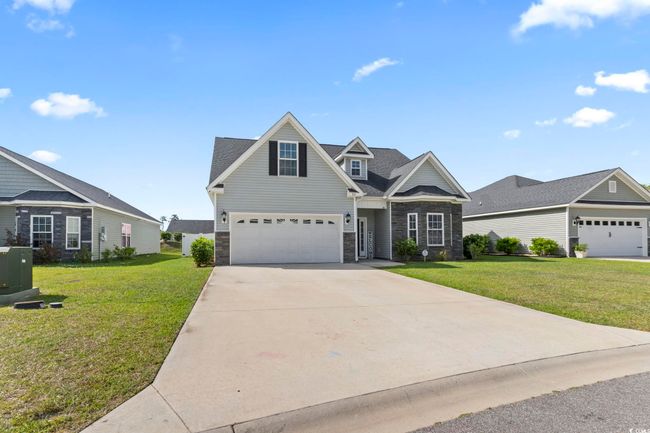 Craftsman-style house with a garage, driveway, stone siding, and a front lawn | Image 39