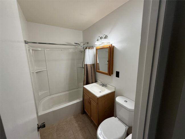 Bathroom featuring toilet, vanity, shower / tub combo, and tile patterned floors | Image 11