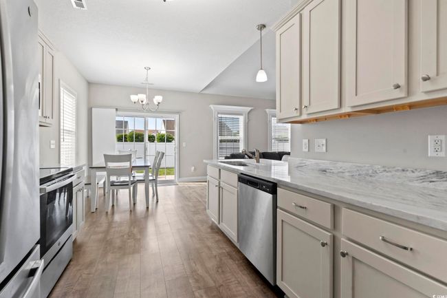 Kitchen with pendant lighting, a sink, dark wood-style floors, a chandelier, and stainless steel appliances | Image 10