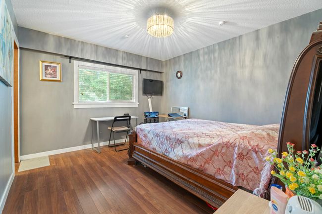 Bedroom with a notable chandelier, baseboards, and wood finished floors | Image 16