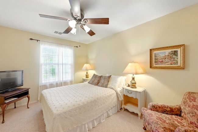 Bedroom with a ceiling fan, baseboards, and light colored carpet | Image 24