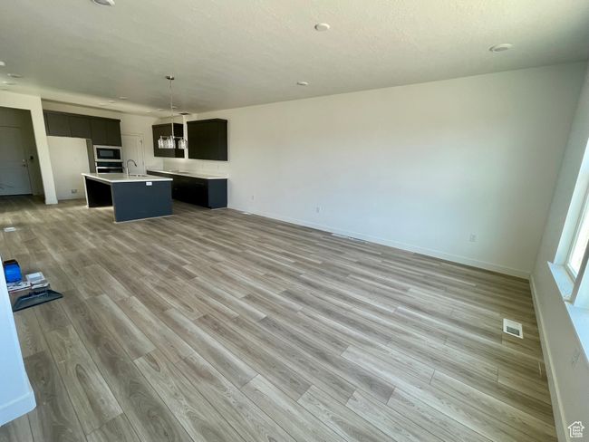 Unfurnished living room featuring light wood-style flooring | Image 5