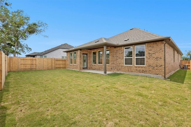 Back of property with brick siding, a patio, a shingled roof, and central air condition unit | Image 23