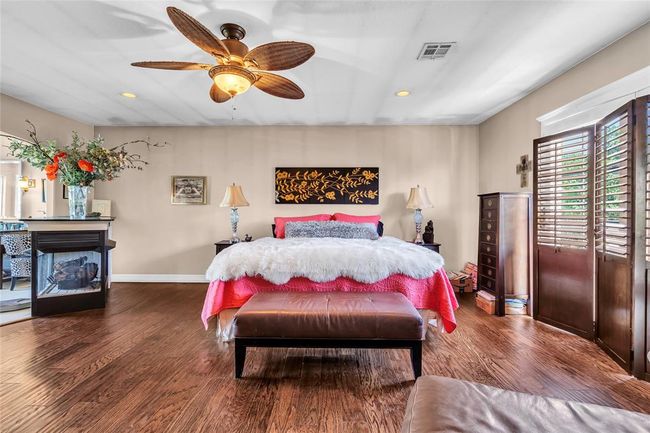 Bedroom with recessed lighting, dark wood-type flooring, ceiling fan, baseboards, and a fireplace | Image 18