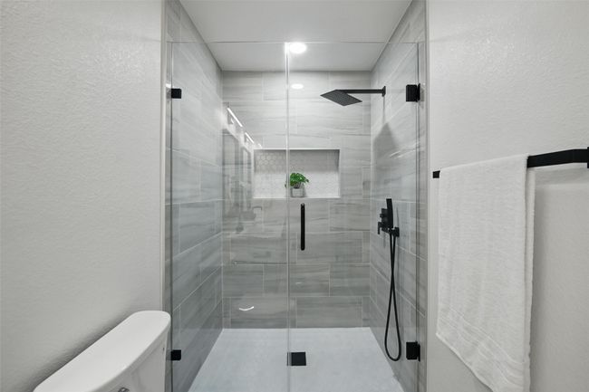 Bathroom featuring toilet, a stall shower, and a textured wall | Image 31