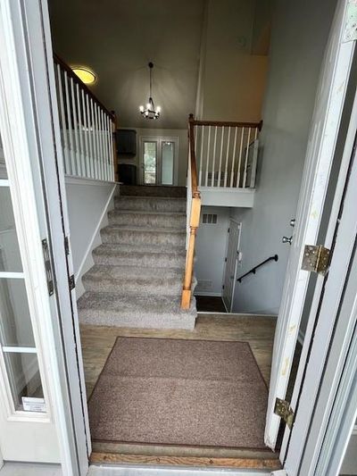 Stairway featuring a notable chandelier | Image 1