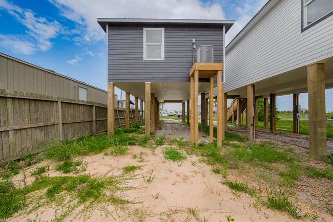 From the back of the property, you can see the terrain stretch from front to rear, with open space beneath the elevated structure offering a glimpse of the lot's full depth. | Image 32