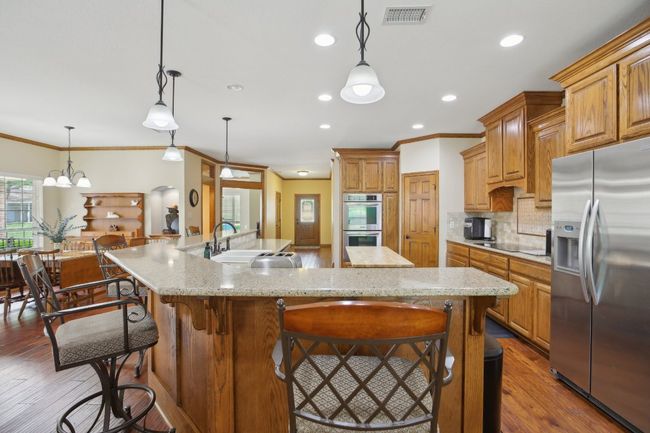 Kitchen with visible vents, hardwood / wood-style flooring, tasteful backsplash, appliances with stainless steel finishes, and a sink | Image 6