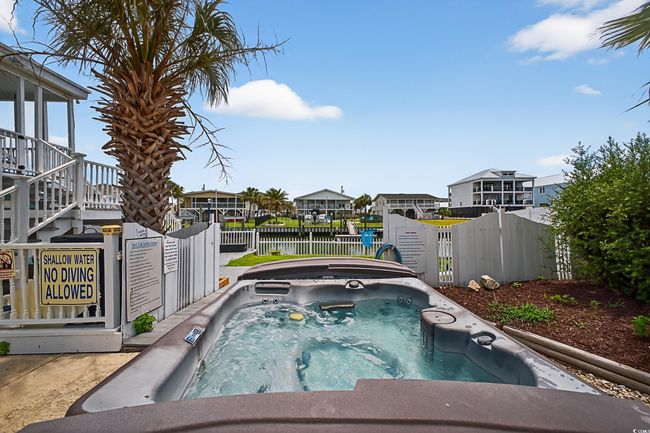 View of swimming pool with an outdoor hot tub, a water view, and a residential view | Image 39