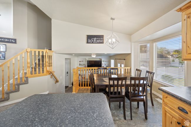 Dining room featuring stairs, a chandelier, and high vaulted ceiling | Image 6