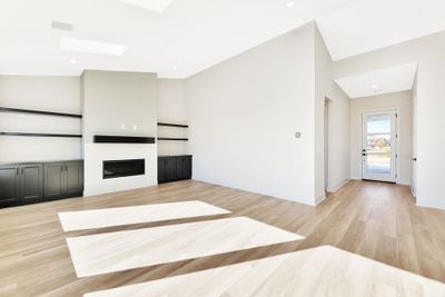 Unfurnished living room featuring lofted ceiling and light wood-type flooring | Image 3