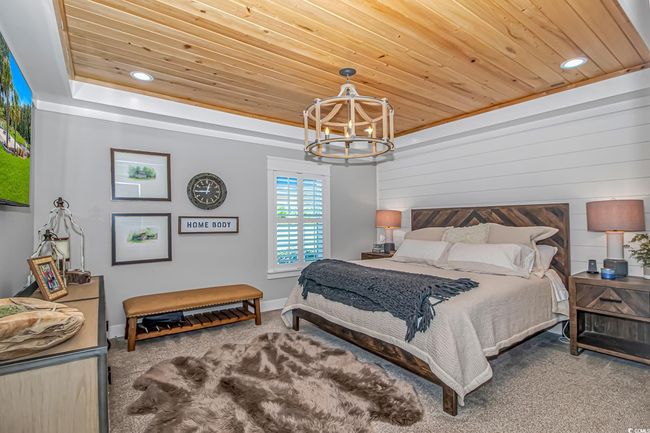 Carpeted bedroom featuring a chandelier, wood ceiling, recessed lighting, and wood walls | Image 17