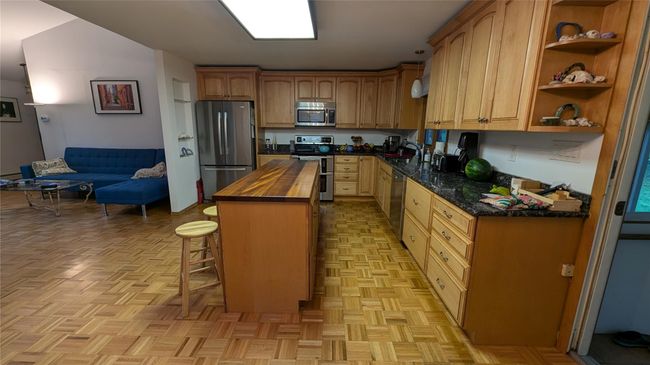 Kitchen with appliances with stainless steel appliances, granite counters a sink, a kitchen breakfast bar, and a center island with seating | Image 6