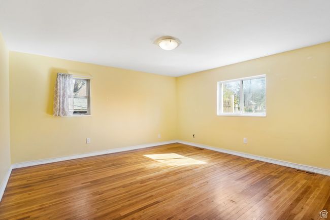 Empty room with visible vents, hardwood / wood-style flooring, and baseboards | Image 35