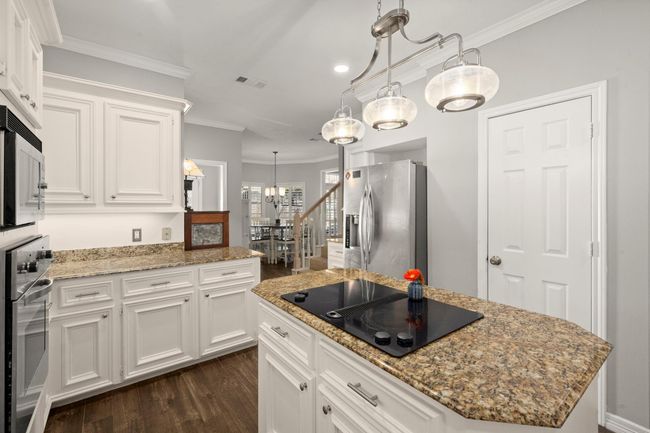 Chrome hardware, faucet, and lighting coordinate with the stainless appliances and sink. | Image 17