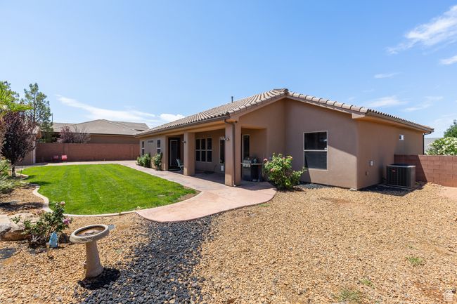 Rear view of property with a fenced backyard, stucco siding, a tile roof, and a patio | Image 11