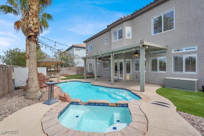 View of pool with a fenced backyard, a pool with connected hot tub, a ceiling fan, a patio, and french doors | Image 37