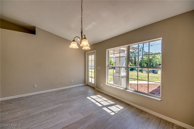 Unfurnished room featuring an inviting chandelier, a wealth of natural light, and light wood-style floors | Image 11