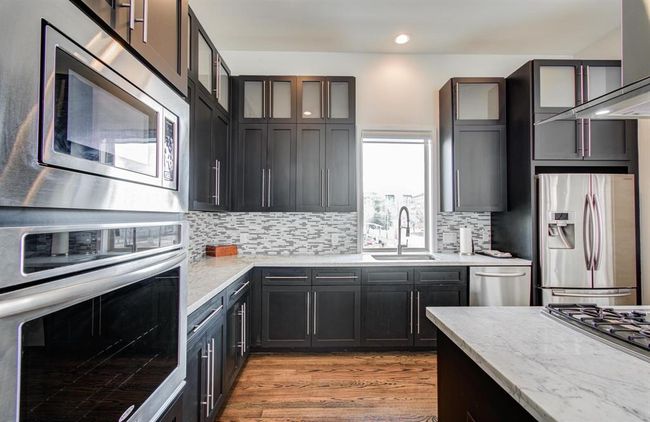 Stainless steal appliances in this stunning kitchen with a window overlooking the city. | Image 15