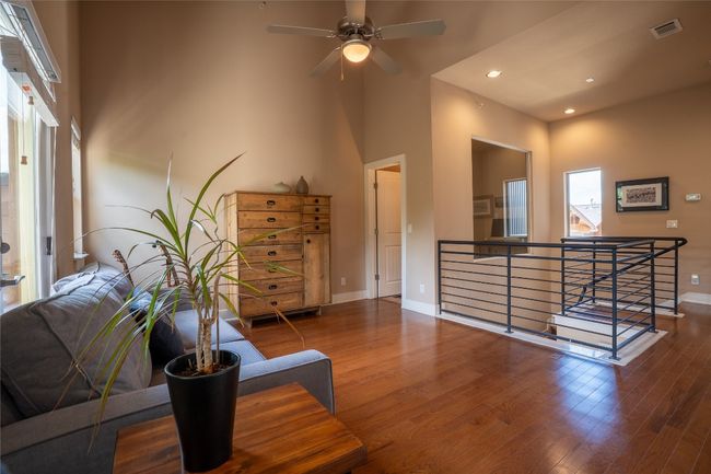 Sitting room featuring an upstairs landing, wood finished floors, ceiling fan, recessed lighting, and a high ceiling | Image 15